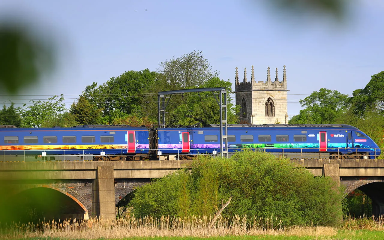 Hull Trains passing over a bridge with a church in the background